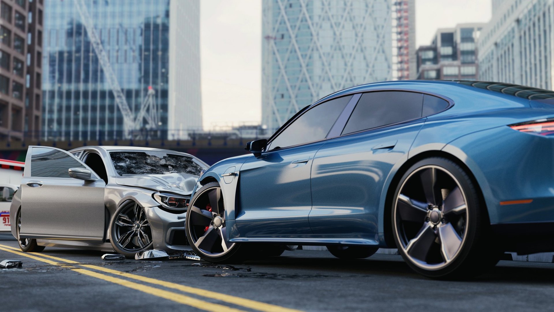 Two cars in a head-on collision on a city street with tall buildings in the background
